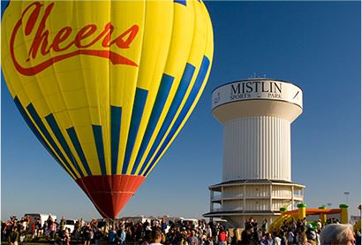 A hot air balloon floating next to a large tower