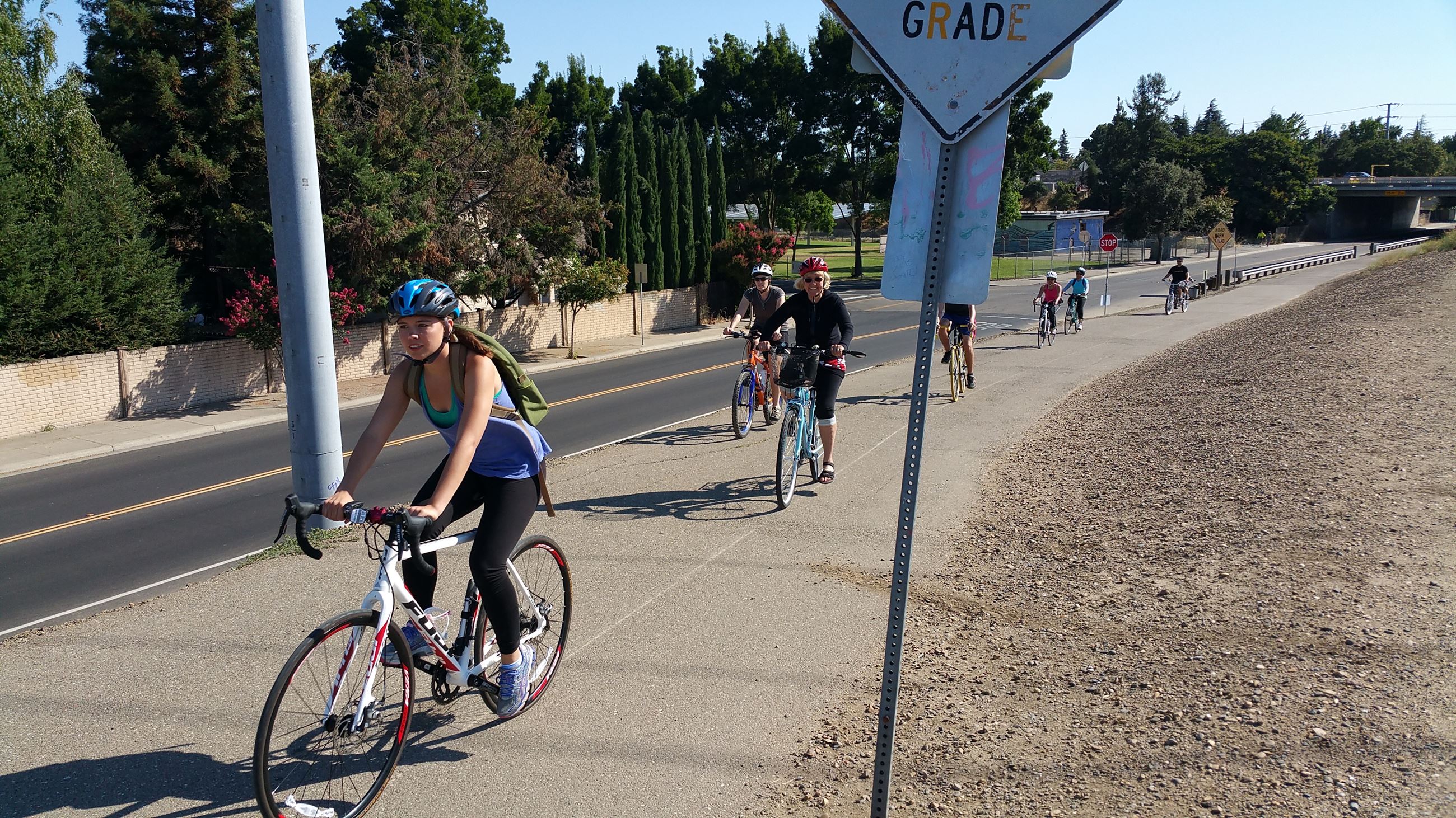 Several cyclists riding on a bikeway.