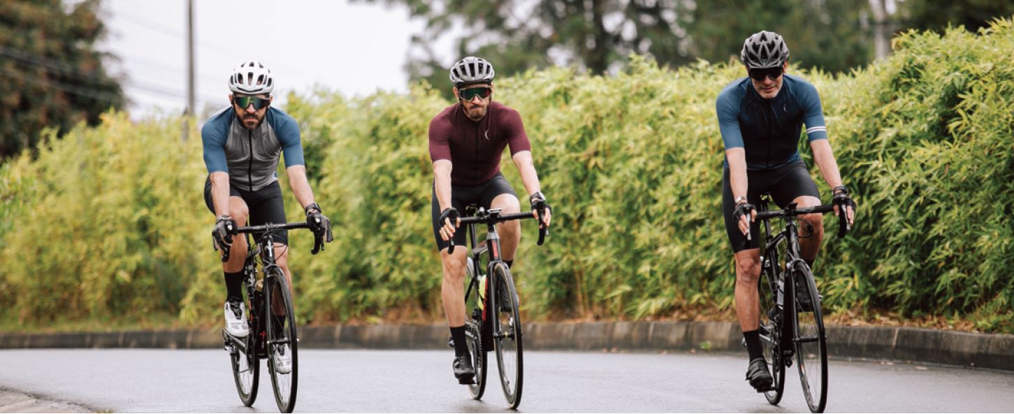 Three cyclists shown on a ride in the country.